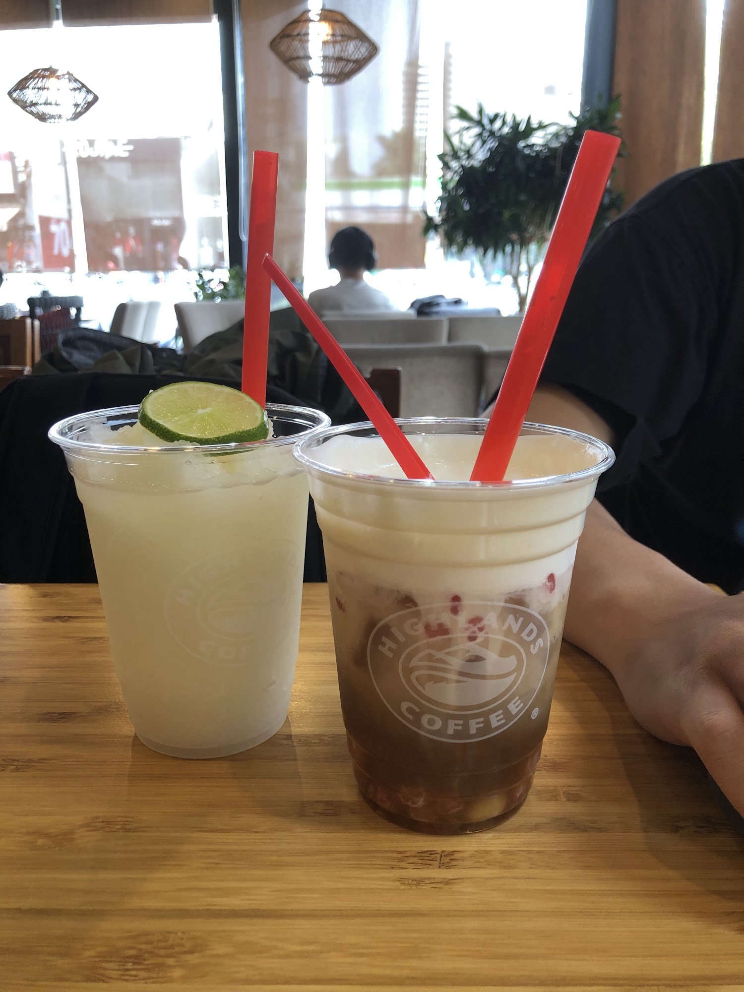 Two beverages on a wooden table in an indoor setting, likely a café or restaurant.