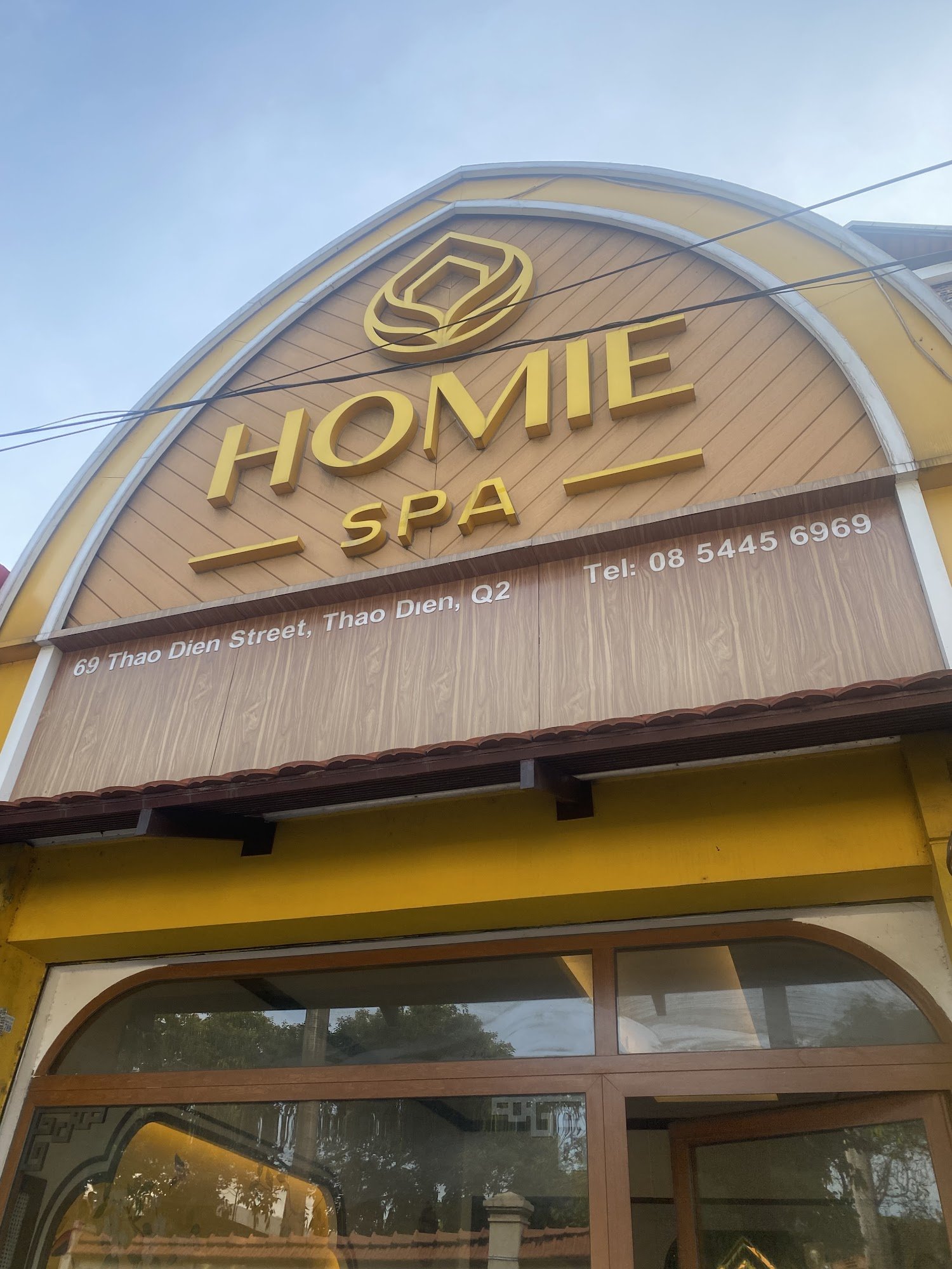The image shows an exterior view of a spa named 'HOMIE SPA' located at Thao Dien Street in Saigon.