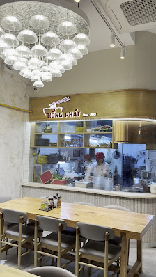 The image depicts the interior of a café named "LION DRIFT" located in Thao Dien, Saigon. It features a modern design with a wooden counter, several c