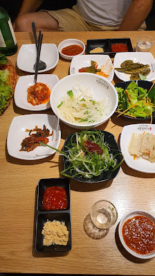 A variety of Korean dishes including kimchi, noodles, and vegetable side dishes