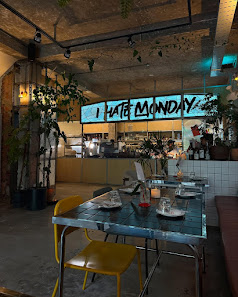 An interior view of a casual dining venue in Thao Dien, Saigon. Features include a glass-top table with yellow chairs, plates and glasses set for dini