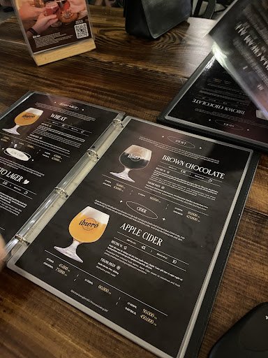 The image shows a menu from Thao Dien, Saigon featuring various beverage options such as beer, brown chocolate, and apple cider with corresponding ima