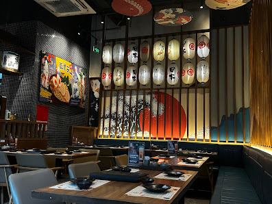 The image depicts the interior of a restaurant in Thao Dien, Saigon. It features wooden tables with black bowls and plates, gray chairs, and booth sea