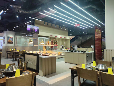 The image shows an interior view of a modern restaurant or cafe in Thao Dien, Saigon. The space is well-lit with overhead lighting and features variou