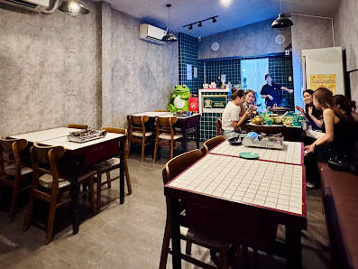 The image shows an indoor dining area in a restaurant or cafe setting at Thao Dien, Saigon. The space is modern with gray walls and blue-tiled accents