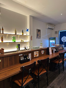 The image shows an interior view of a modern bar or restaurant setting in Thao Dien, Saigon. The counter is equipped with various bottles and glasses 