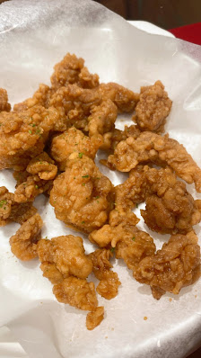 A plate of golden-brown fried food items on a white paper-lined tray.