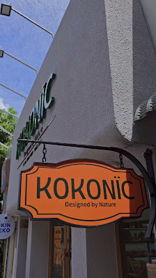 Exterior shot of a commercial building in Thao Dien, Saigon. Features a prominent orange sign with 'KOKONIC' and 'Designed by Nature' text. The buildi