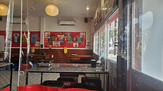 The image shows an interior view of a restaurant or cafe located in Thao Dien, Saigon. The space features red and white decor with various posters on 