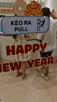 The image shows a part of an interior space in Thao Dien, Saigon with two children standing near what appears to be the counter or service area of a f