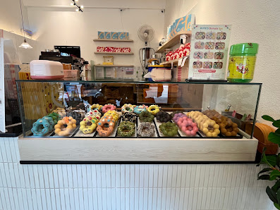 The image shows a display case in an interior setting of what appears to be a bakery or café. The counter is white, and the glass display case contain