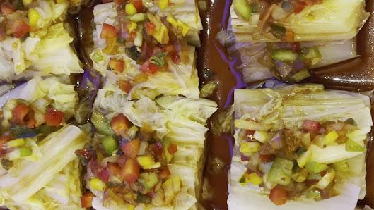 The image shows a close-up of what appears to be a dish consisting of cabbage leaves filled with a colorful mixture that includes chopped vegetables s
