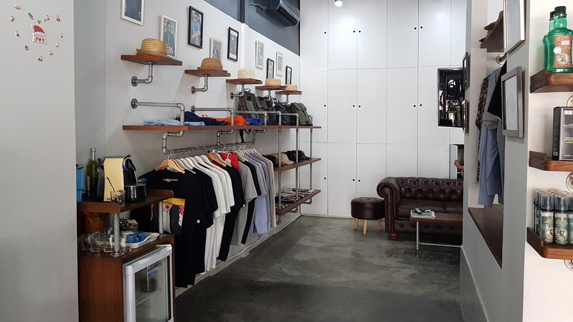 This image depicts an interior view of a clothing store located in Thao Dien, Saigon. The space is well-organized with various shelves displaying hats