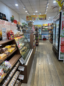 The image shows an interior view of a convenience store or small grocery shop. The shelves are stocked with various packaged goods, including snacks a