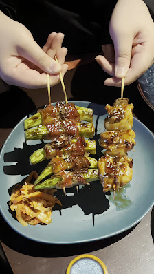 A plate of skewered vegetables and mushrooms coated in a glossy sauce.