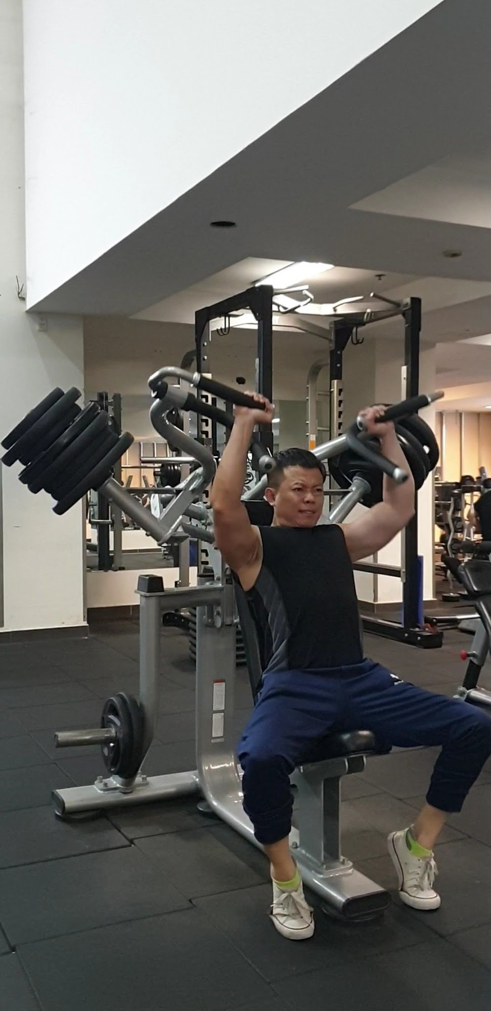 A person is exercising on a leg press machine in an indoor gym setting.