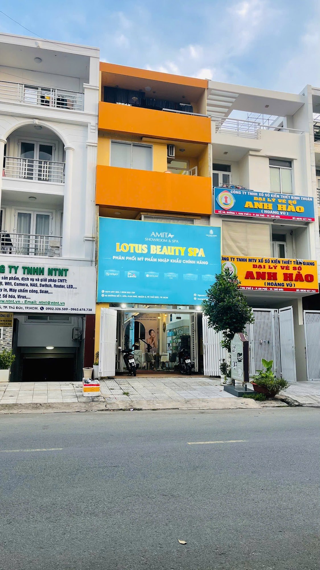 The image shows a commercial building on the street level in Thao Dien, Saigon with multiple businesses advertised on its facade.