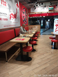 The image depicts the interior of a restaurant in Thao Dien, Saigon. It features red and white decor with red cushioned seating, wooden tables, and a 