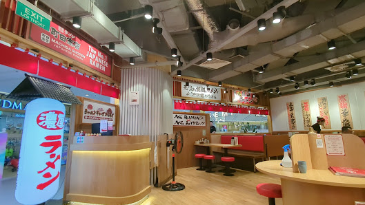 The image depicts the interior of a Japanese restaurant located in Thao Dien, Saigon. It features a modern design with wooden furniture, red seating b