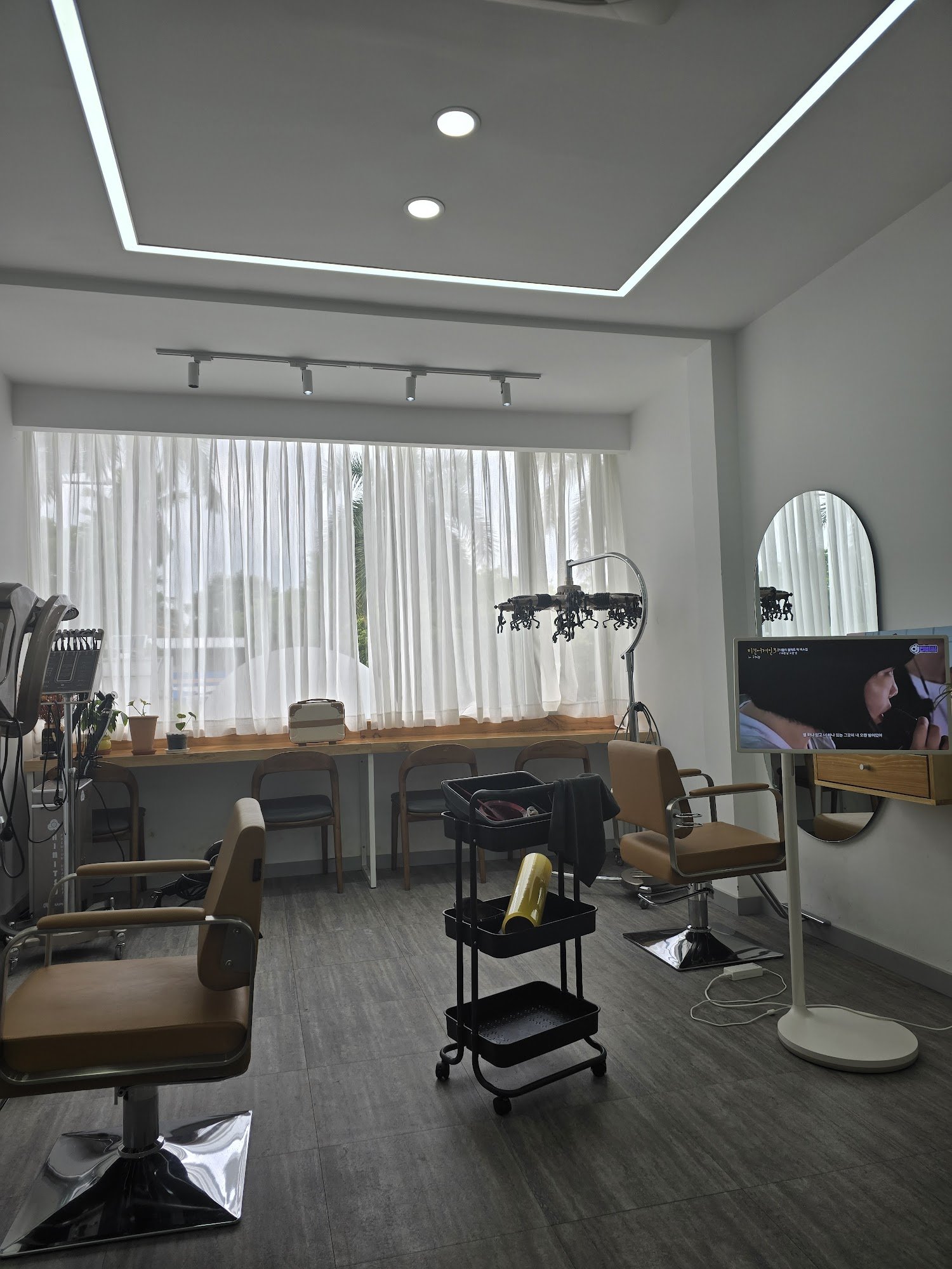 The image depicts a modern and well-lit interior of what appears to be a beauty salon or hair studio in Thao Dien, Saigon. The space is equipped with