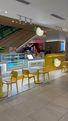 The image shows an interior view of a modern and brightly lit food establishment named 'Grab'. The decor features yellow accents, including seating ar