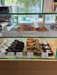 The image shows a display case in an establishment named Thao Dien, Saigon containing various types of cookies and pastries with labels indicating the