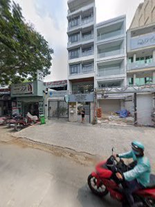 The image shows a street view of an urban area in Thao Dien, Saigon with multi-story buildings and parked motorcycles on the road.