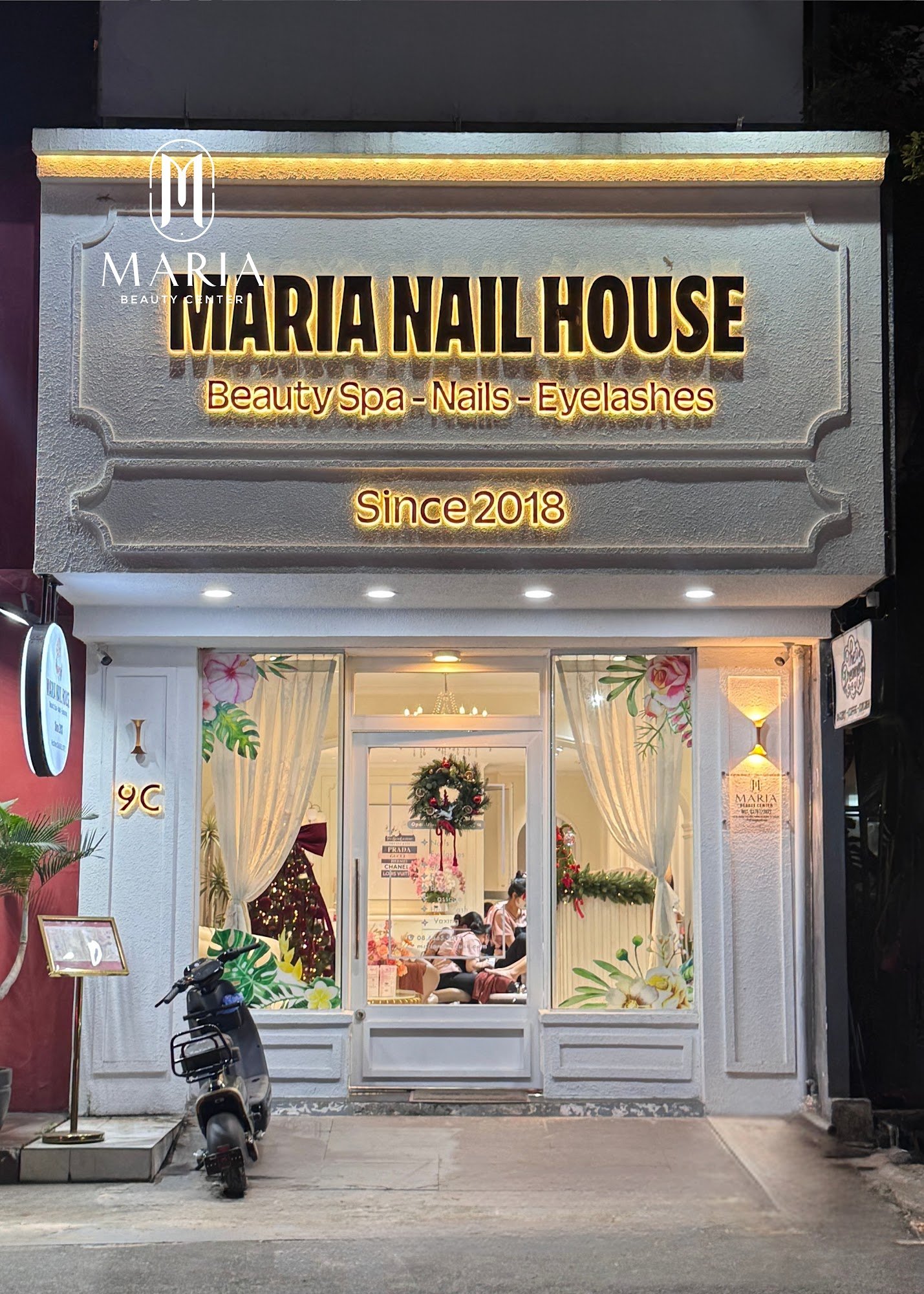 The image shows an exterior view of Maria Nail House in Thao Dien, Saigon. The establishment is a beauty spa offering nail and eyelash services since 