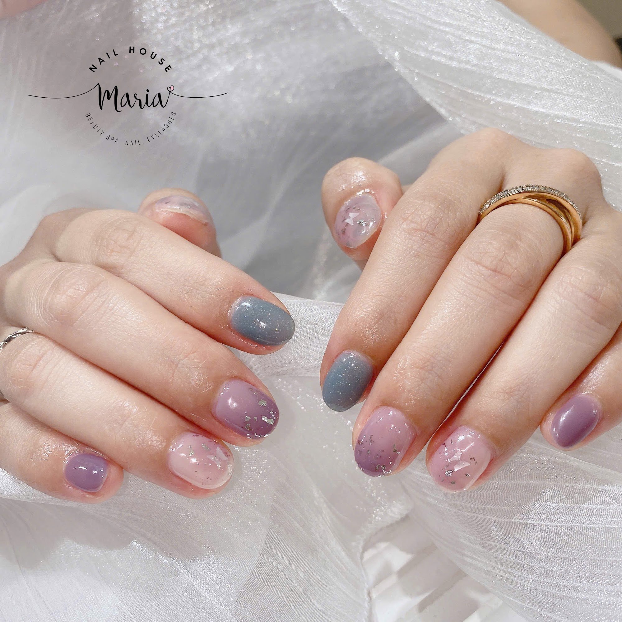 A close-up of a person's hands displaying their manicured nails at 'Nail House Maria', which is indicated by the watermark on the image.