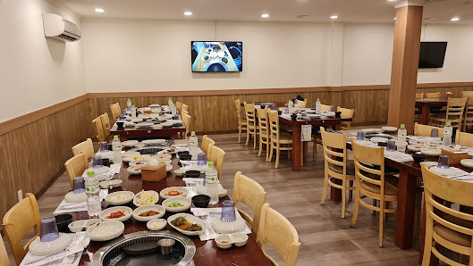 A spacious restaurant interior in Thao Dien, Saigon, featuring multiple wooden tables set with dining ware, plates of food, and drinks. Light-colored 