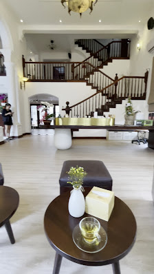 The image shows a spacious and well-lit interior of what appears to be a high-end venue in Thao Dien, Saigon. The focal point is a large wooden stairc