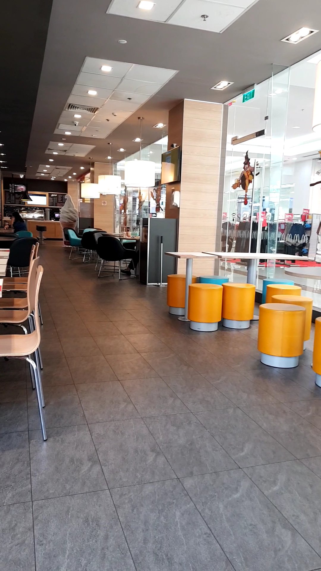 The image depicts the interior of a modern café or restaurant in Thao Dien, Saigon. It features a spacious layout with dark gray tiled flooring. On th