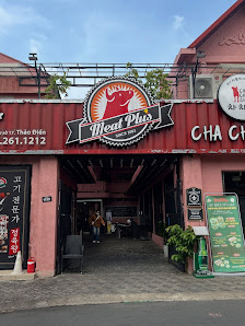 Exterior view of a venue in Thao Dien, Saigon. The building features a pinkish facade with a prominent circular sign for 'The Meat Pub' displaying a c
