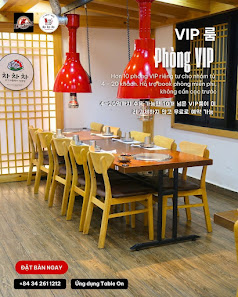 The image shows an interior view of a restaurant named 'VIP Phong VIP' with red pendant lights hanging above wooden tables and chairs, set against a b