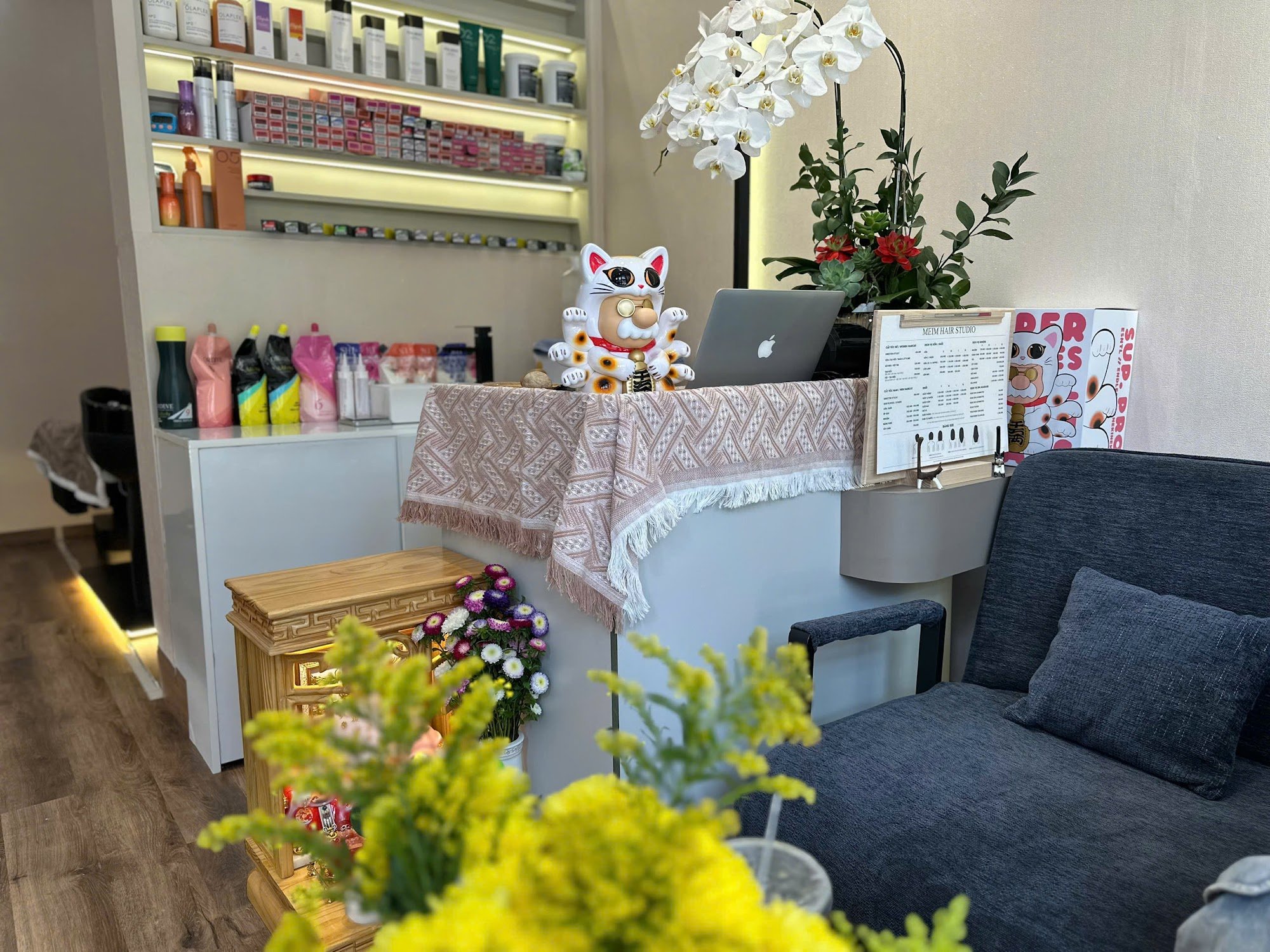 The image shows an interior space that appears to be a beauty salon or spa. There is a desk with various products, including hair care items and cosme