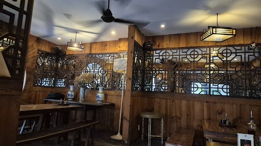 The image shows an interior view of a restaurant or bar in Thao Dien, Saigon with wooden walls and decorative metalwork on the partitions.