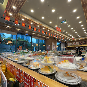 The image depicts the interior of a restaurant in Thao Dien, Saigon, featuring a buffet-style food display with various dishes in plastic containers o