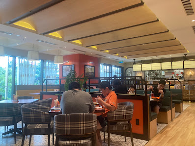 The image shows an interior view of a restaurant or cafe in Thao Dien, Saigon with modern decor featuring wooden beams on the ceiling and large window