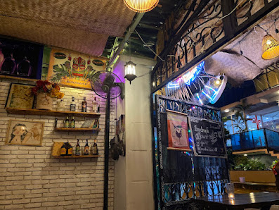 The image shows an interior view of a restaurant or bar in Thao Dien, Saigon with exposed brick walls and various decorations including neon signs, bo