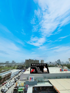 The image captures an exterior view of a commercial complex in Thao Dien, Saigon, under a bright blue sky with scattered clouds. Visible elements incl