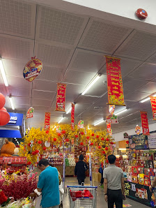 The image depicts the interior of a bustling retail store in Thao Dien, Saigon, Vietnam. The space features vibrant red and gold festive decorations, 