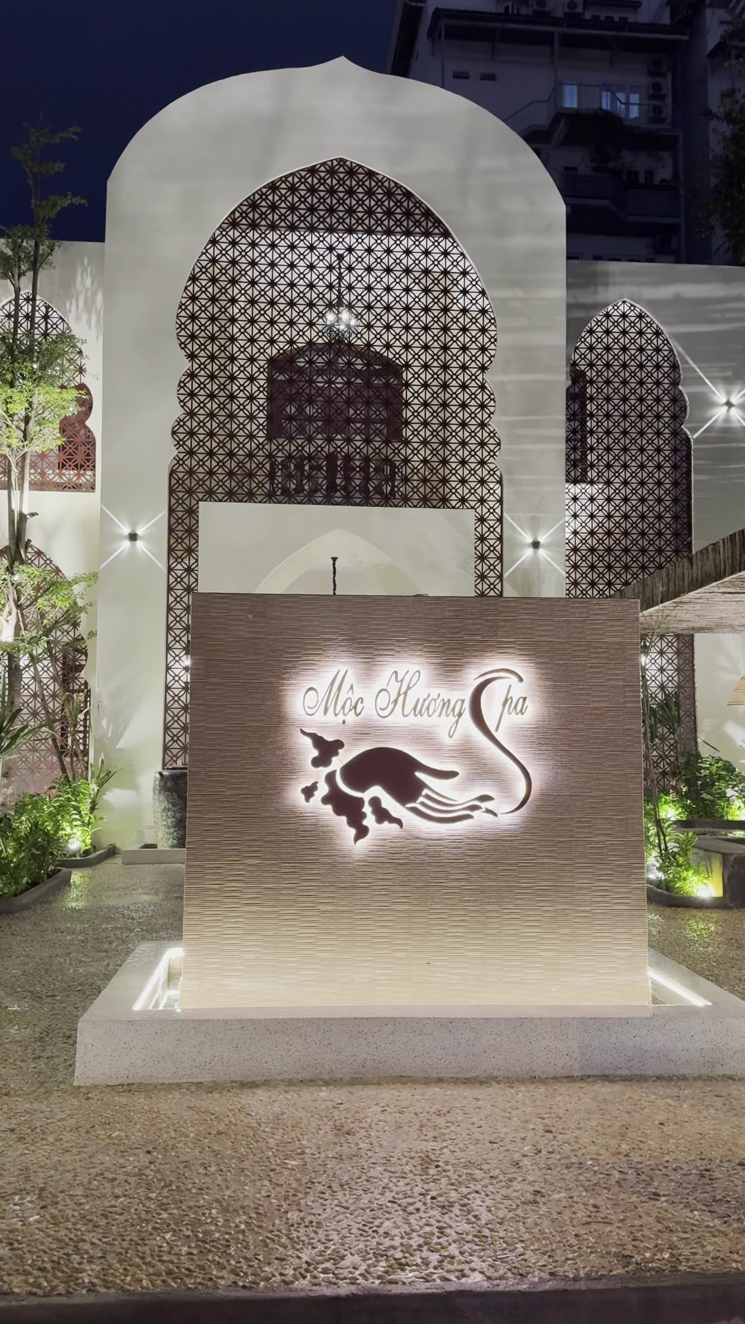 The image shows an exterior view of a spa named 'Mooi Huong Spa' at night time in Thao Dien, Saigon.