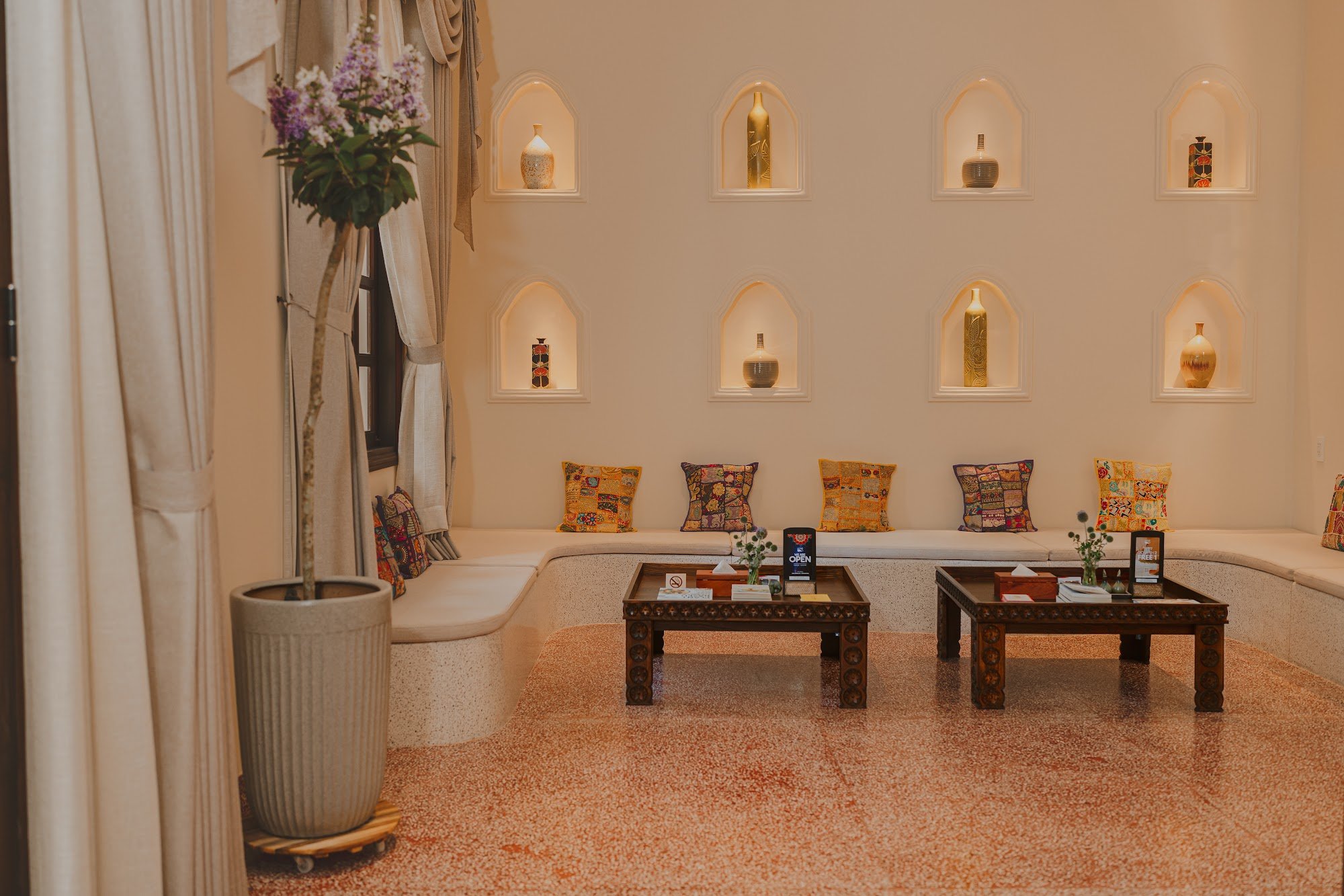 This image depicts an interior space that appears to be a lounge or waiting area in Thao Dien, Saigon. The room is well-lit with warm lighting and fea