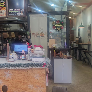 The image shows an interior view of a cafe or restaurant named 'Merry Cafe'. The decor includes festive elements such as Christmas decorations and wre