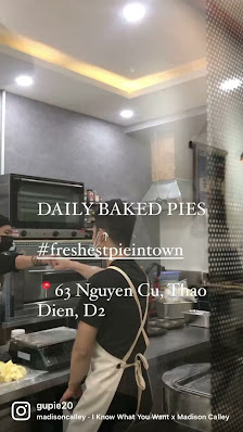 A person is working in a kitchen environment where baked pies are being prepared and displayed on the counter.