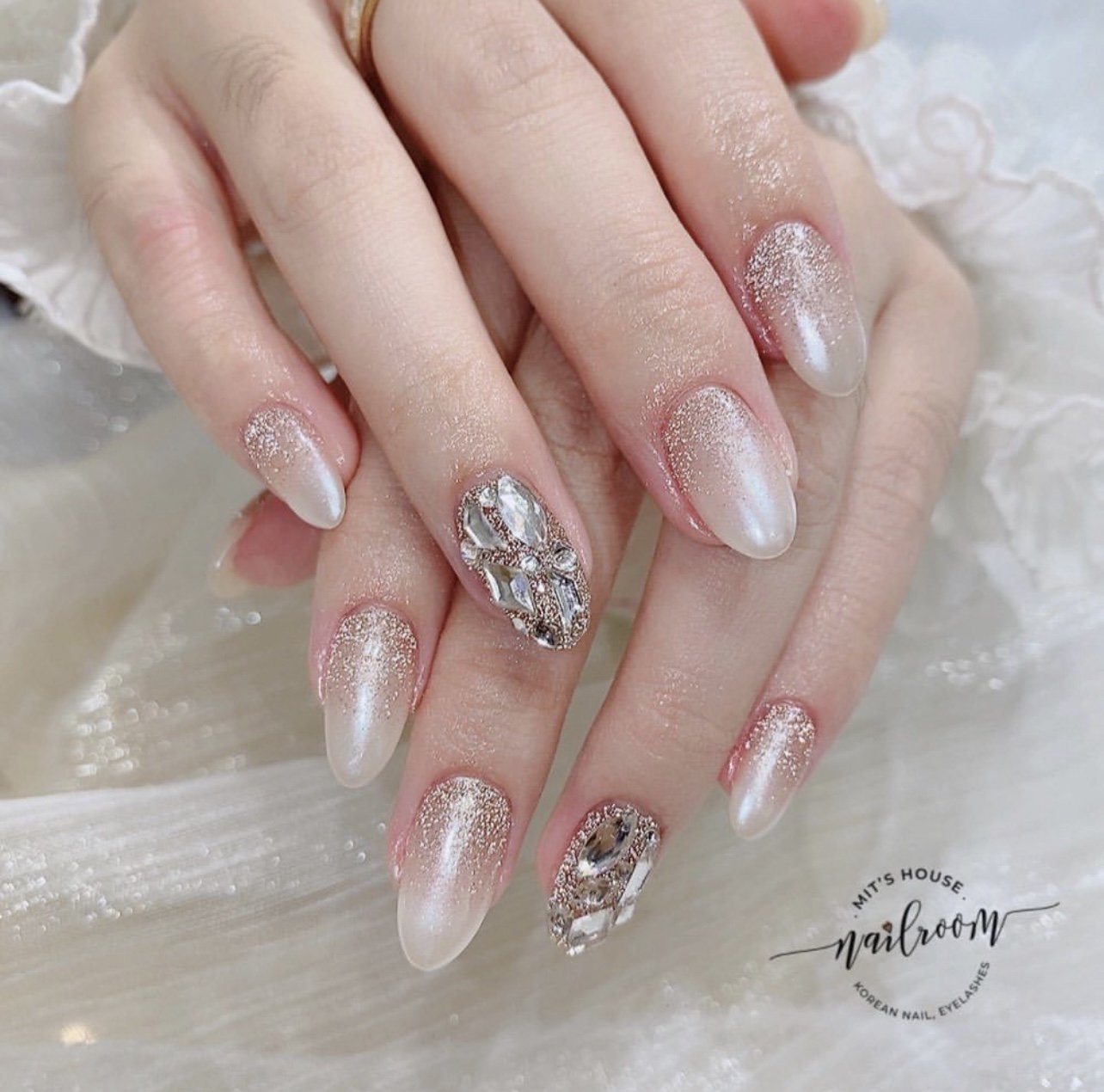 The image features a close-up of a hand with meticulously designed nails. The nails have a gradient from soft pink at the cuticle to a clear, glossy f