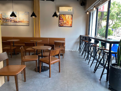 The image shows an interior view of a cafe or restaurant in Thao Dien, Saigon. The space is well-lit with natural light coming through the large windo