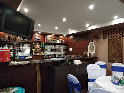 The image shows an indoor setting of a bar or restaurant in Thao Dien, Saigon. The interior features wooden paneling on the walls and ceiling with rec