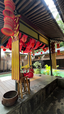 The image shows an outdoor area of a traditional Vietnamese establishment featuring red lanterns and incense smoke rising from the table, indicating i