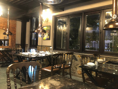 The image shows an interior view of a restaurant or cafe in Thao Dien, Saigon. The space features wooden chairs and tables with metal frames, creating